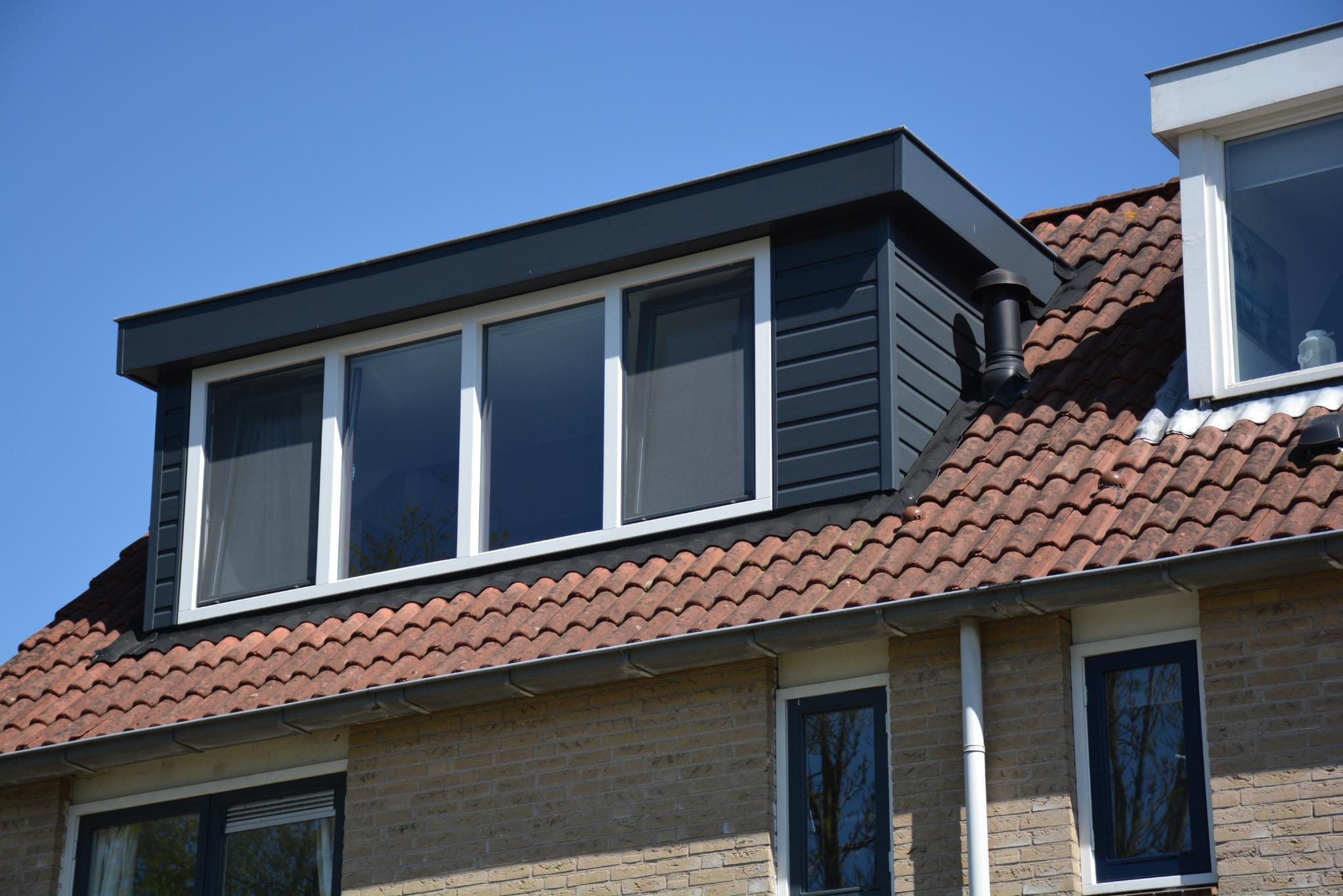 kunststof-kozijnen-dakkapel-soest Moderne donkere dakkapel met strakke witte kunststof kozijnen op een woning in Soest.